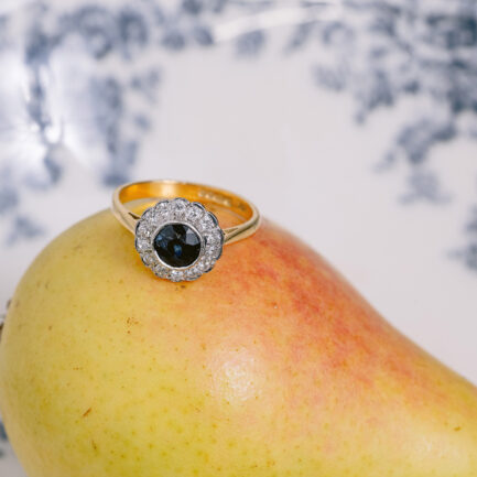 ANILLO MARGARITA EN ORO AMARILLO Y BLANCO CON DIAMANTES Y ZAFIRO CENTRAL.